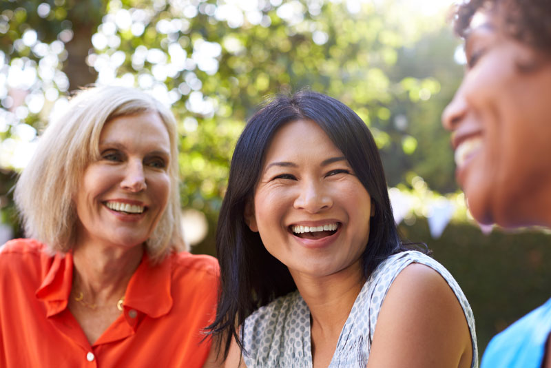 patient and a group of friends laughing outside of the dental practice